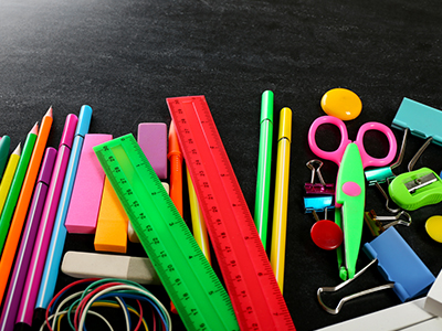 Neon-colored school supplies on black background